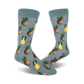 Close up view of a pair of blue crew socks with a repeated pineapple pattern. Pineapples are yellow and brown.