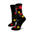 A pair of black crew socks with a whimsical garden print. Red poppies, yellow daffodils, purple flowers, and a red watering can are featured on a black background.
