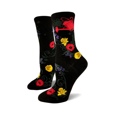 women's black crew socks feature red, yellow, and purple flowers and a red watering can pattern, perfect for the gardening enthusiast.   