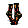 A pair of black crew socks with a fun pattern of red chili peppers and orange habanero peppers.