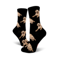 Pair of black crew socks covered in images of golden retrievers. The dogs are light tan and the background is black.