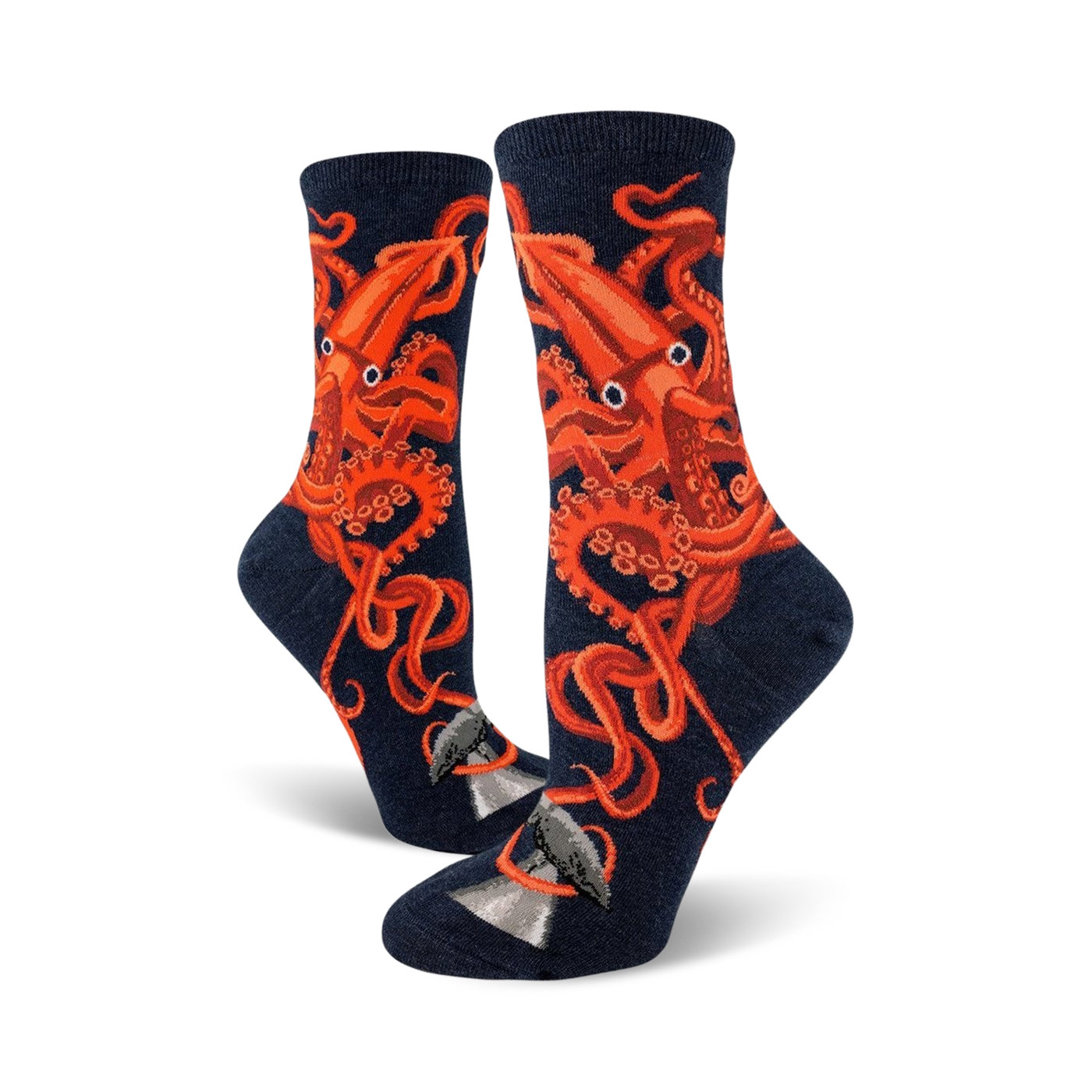 A pair of women's crew socks in navy blue, adorned with a striking orange squid design.  The squid's tentacles wrap around a small grey whale illustration at the bottom.
