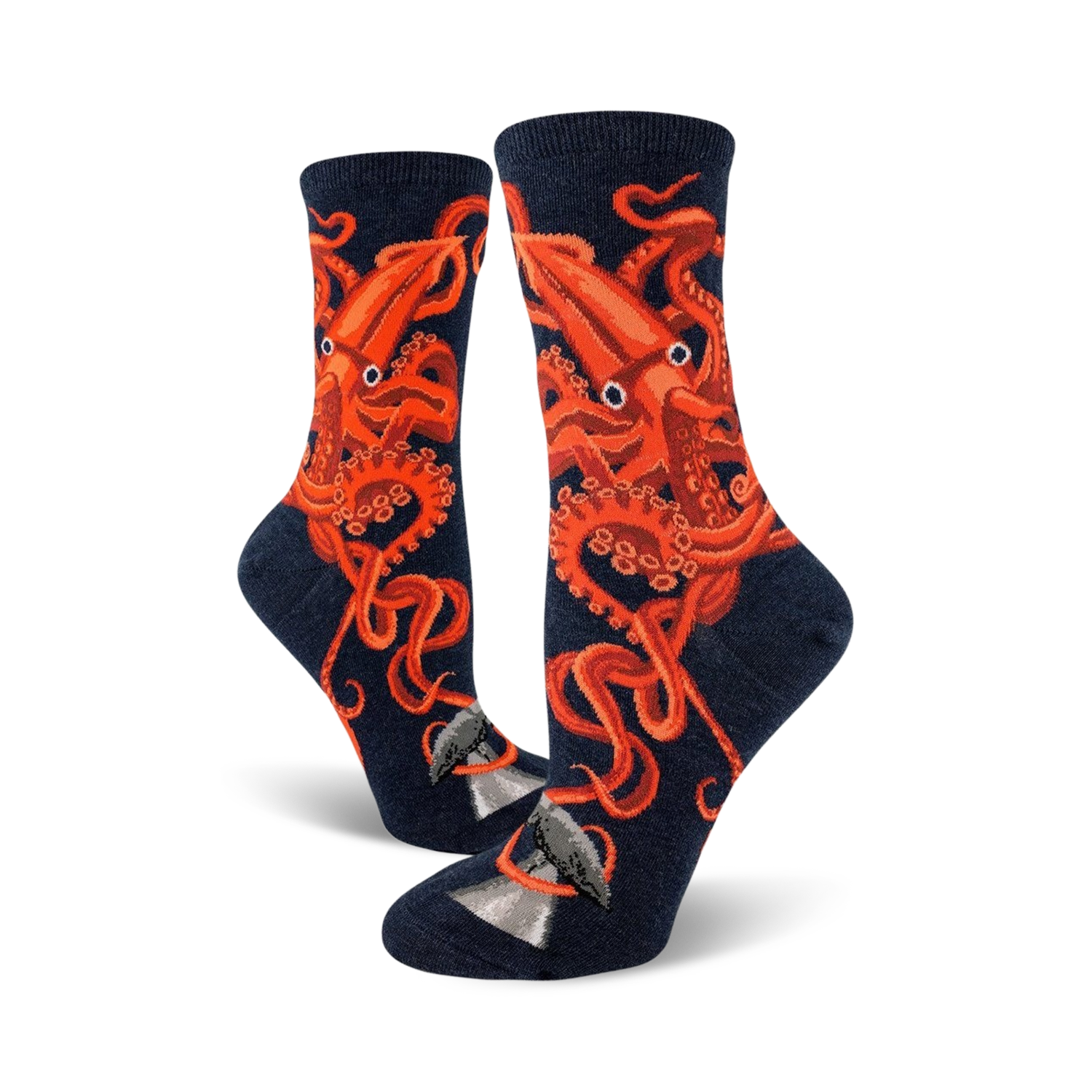 A pair of women's crew socks in navy blue, adorned with a striking orange squid design.  The squid's tentacles wrap around a small grey whale illustration at the bottom.