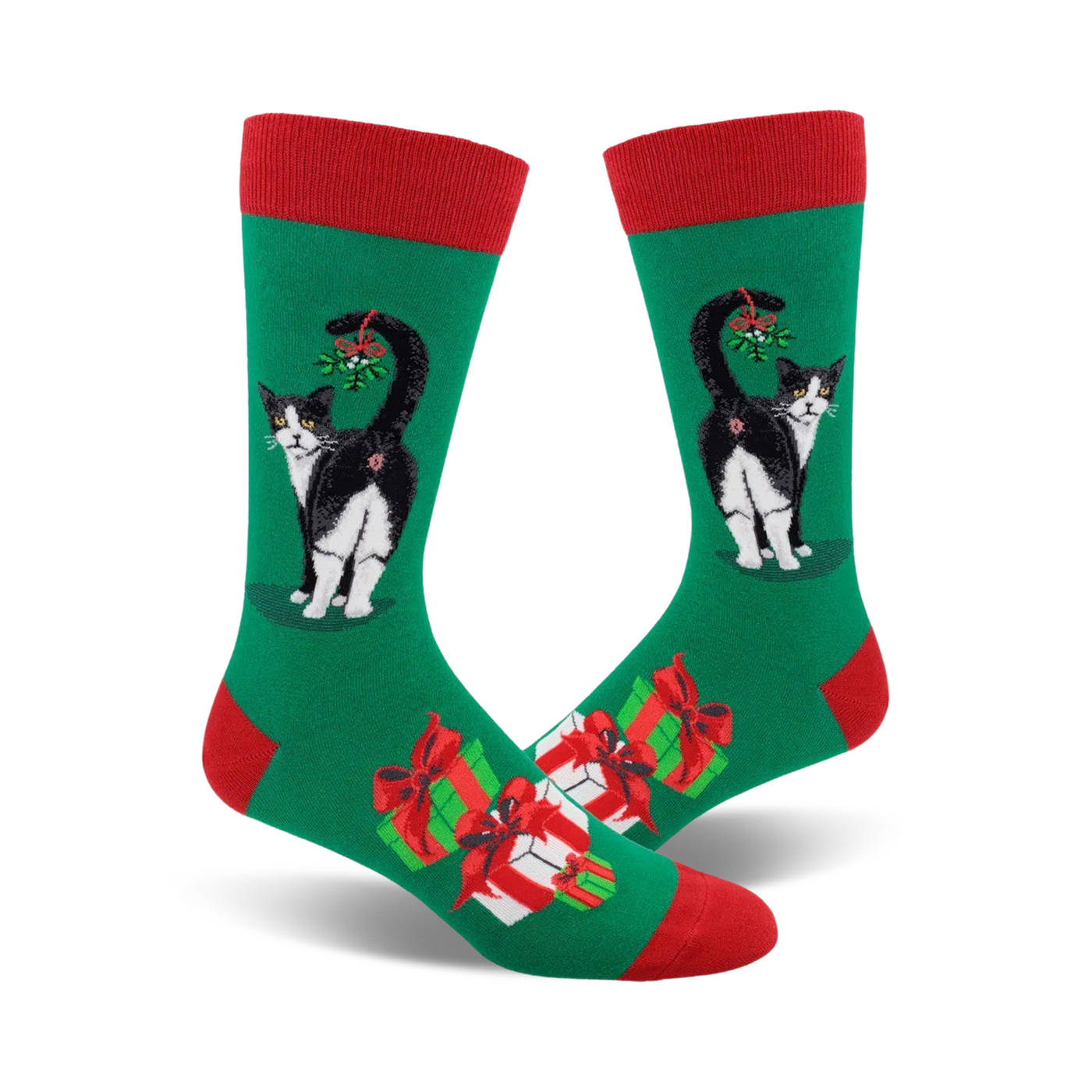 A pair of crew socks. Green background with a black and white cat with mistletoe, plus presents. Red and green accents.