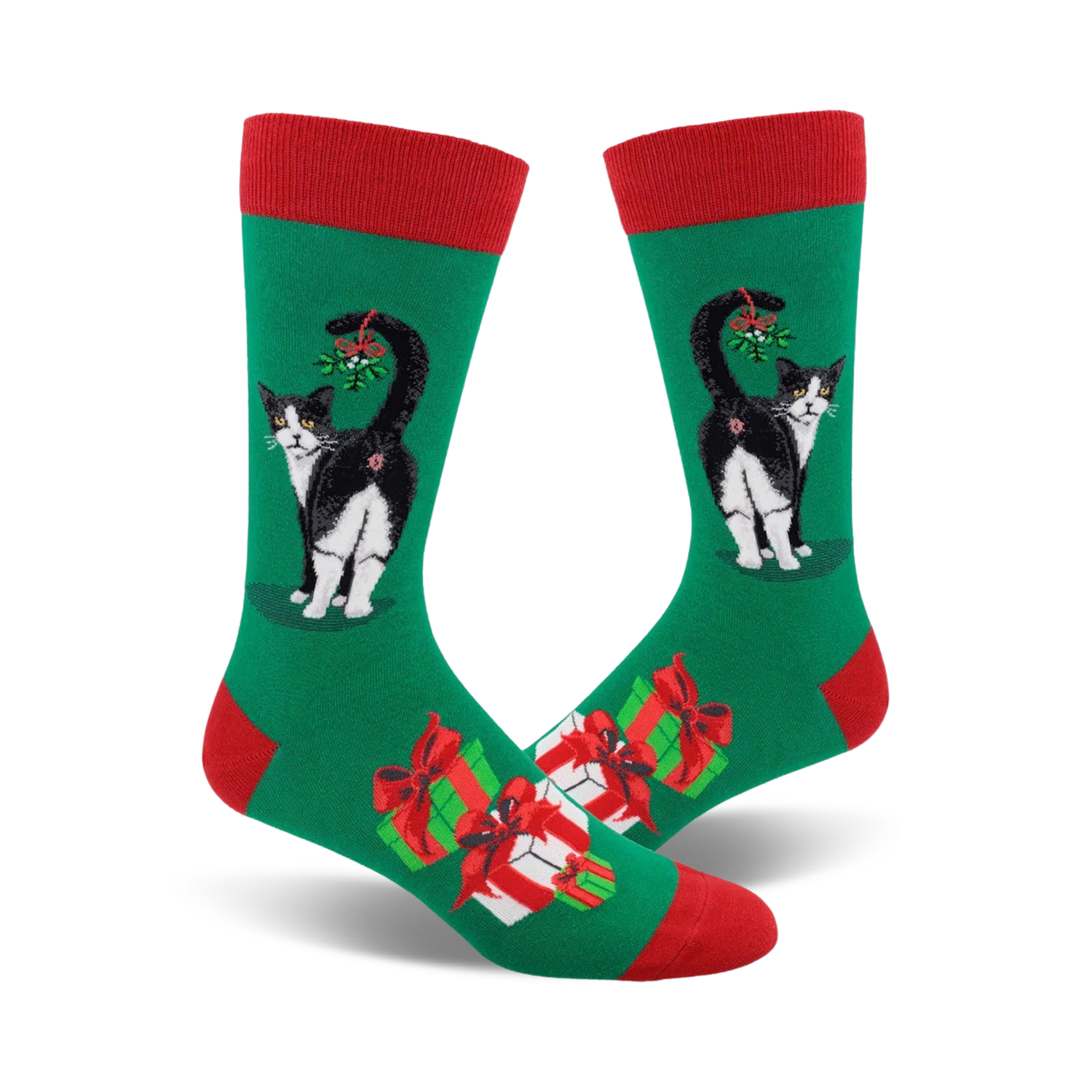 A pair of crew socks. Green background with a black and white cat with mistletoe, plus presents. Red and green accents.