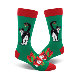 green socks with a red top, black cat with tail up, red and white presents, and mistletoe.    