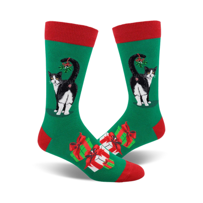 green socks with a red top, black cat with tail up, red and white presents, and mistletoe.    