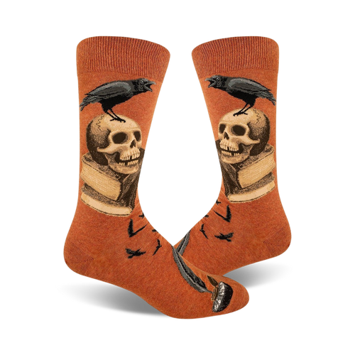 Pair of burnt orange crew socks.  A black raven perches on a skull resting on an open book, with a quill pen at the bottom.  Small ravens also in the background.