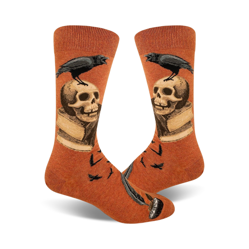 Pair of burnt orange crew socks.  A black raven perches on a skull resting on an open book, with a quill pen at the bottom.  Small ravens also in the background.
