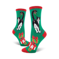 A pair of women's crew socks in green, red, and white. Features a black and white tuxedo cat with mistletoe and presents.