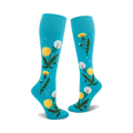Pair of teal knee-high socks with yellow dandelions and green stems printed on them.  Some dandelions are in seed-head form.