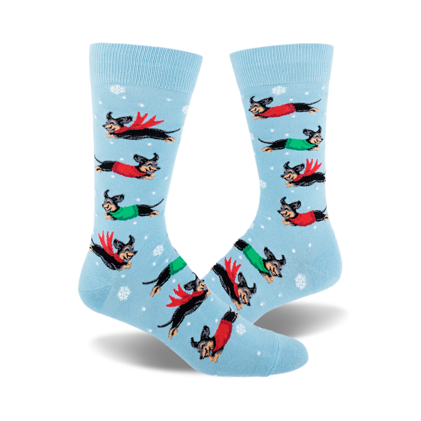 Crew socks in light blue with snowflakes.  Design features dachshunds wearing red and green capes flying across a snowy background.
