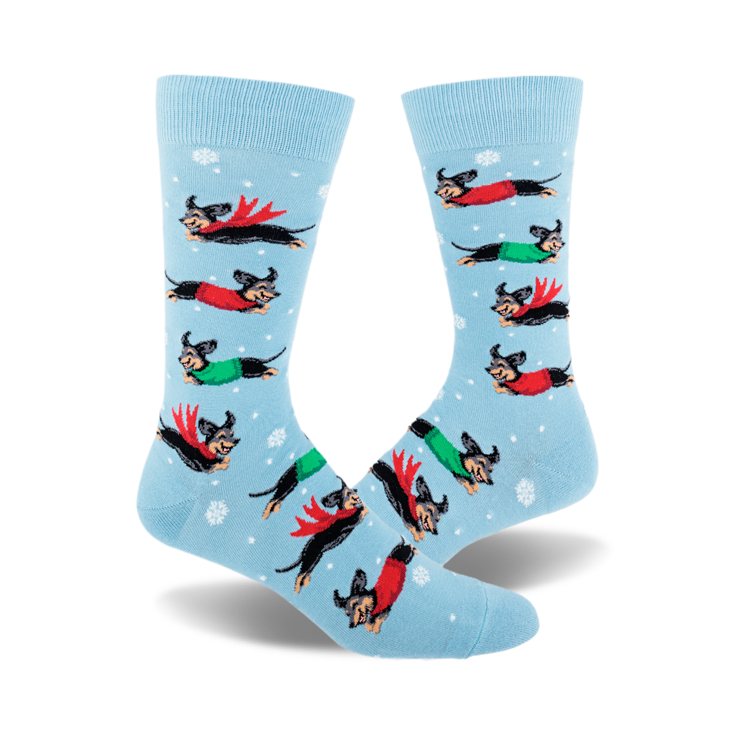 Crew socks in light blue with snowflakes.  Design features dachshunds wearing red and green capes flying across a snowy background.