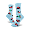 Crew socks in light blue with a repeating pattern of dachshunds wearing red and green sweaters, flying through a snowy scene.
