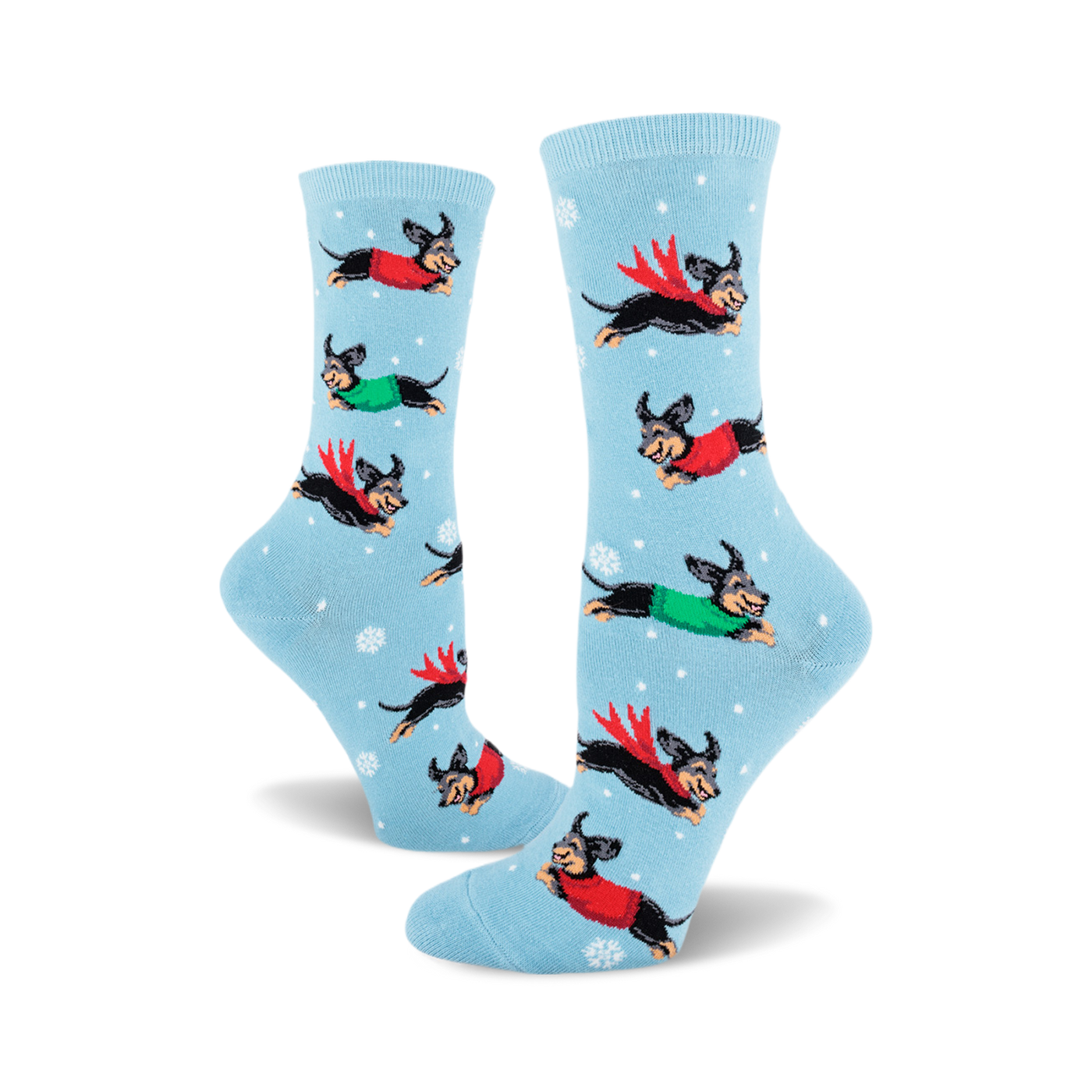 Crew socks in light blue with a repeating pattern of dachshunds wearing red and green sweaters, flying through a snowy scene.