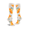 Pair of cream-colored knee-high socks adorned with a repeating pattern of bright orange California poppies and green leaves.