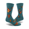 A pair of teal crew socks featuring a pattern of orange monarch butterflies.  A whimsical and nature-inspired design.