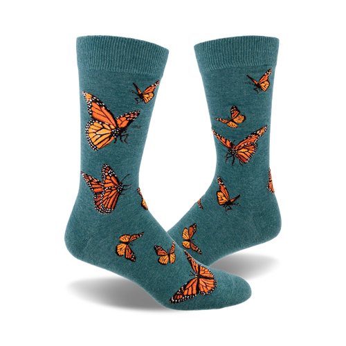 A pair of teal crew socks featuring a pattern of orange monarch butterflies.  A whimsical and nature-inspired design.