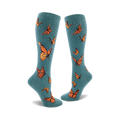 Pair of teal blue knee-high socks adorned with a pattern of orange monarch butterflies. Fun and stylish.