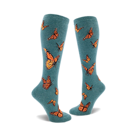 the teal blue socks have a pattern of orange monarch butterflies with black and white details.