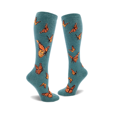 the teal blue socks have a pattern of orange monarch butterflies with black and white details.