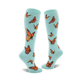 Pair of teal knee-high socks featuring an all-over print of orange monarch butterflies. 