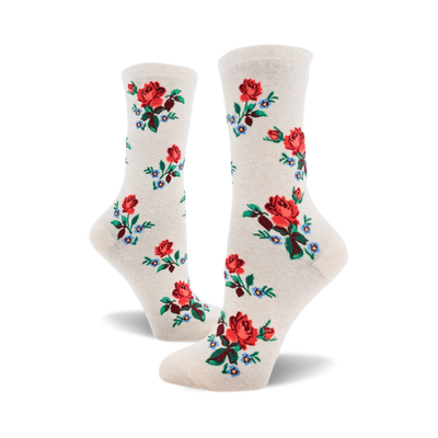 socks with a pattern of red roses with green stems and blue and white flowers with green stems. the background of the socks is off-white.