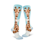 Pair of women's knee-high socks. Light blue background with a whimsical giraffe design in shades of brown and tan.