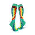 A pair of teal knee-high socks with a whimsical design. Red lips 'puke' a rainbow onto teal clouds and stars.