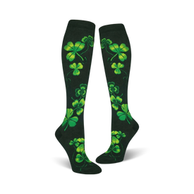 women's knee high shamrock socks featuring a bright green four-leaf clover design on a dark green background. perfect for st. patrick's day.  