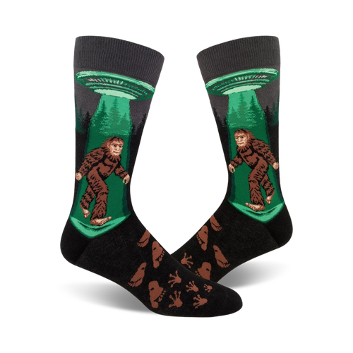 Crew socks in black, green, and brown featuring Bigfoot being beamed up by a UFO.  Footprints are printed on the lower part of the sock.