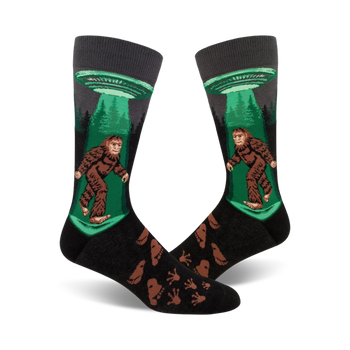crew-length socks depicting sasquatch being beamed up by ufo, black background, with footprints.  