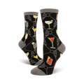 A pair of women's crew socks in black with a gray cuff. The socks feature a pattern of colorful cocktail illustrations set against a dark background.