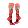 Pair of coral knee-high socks with a rocket launching from a rocky planet design. Features teal, orange, and black details.