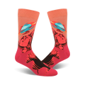 A pair of crew socks with a vibrant design featuring teal rockets launching from a red and black rocky landscape against a peach background.