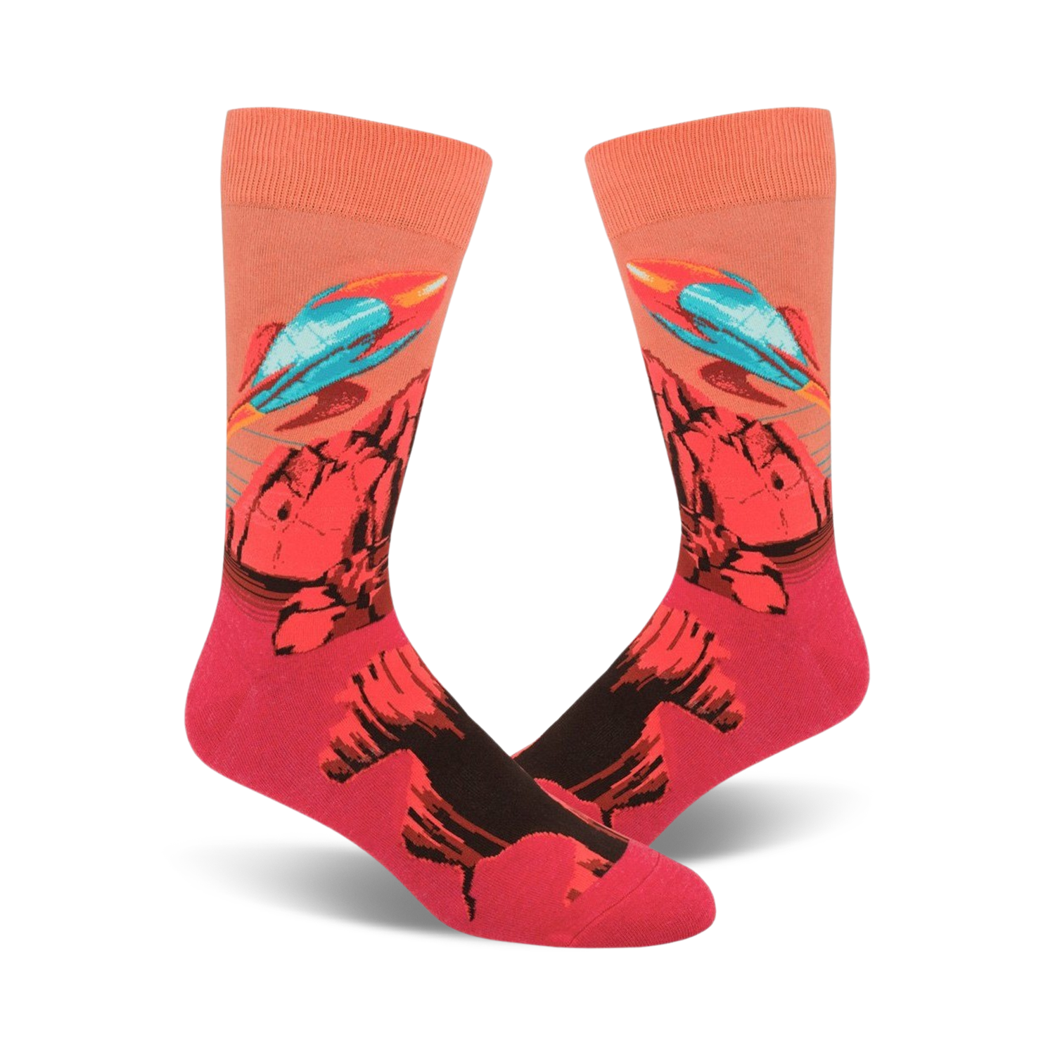 A pair of crew socks with a vibrant design featuring teal rockets launching from a red and black rocky landscape against a peach background.