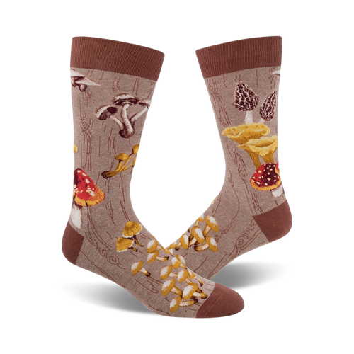 Pair of crew socks with a mushroom design.  The socks are beige/brown and green with various colorful mushroom illustrations on a wood-grain background. 