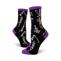 A pair of black crew socks with purple cuffs.  The socks are adorned with a pattern of white skeletons performing yoga poses.