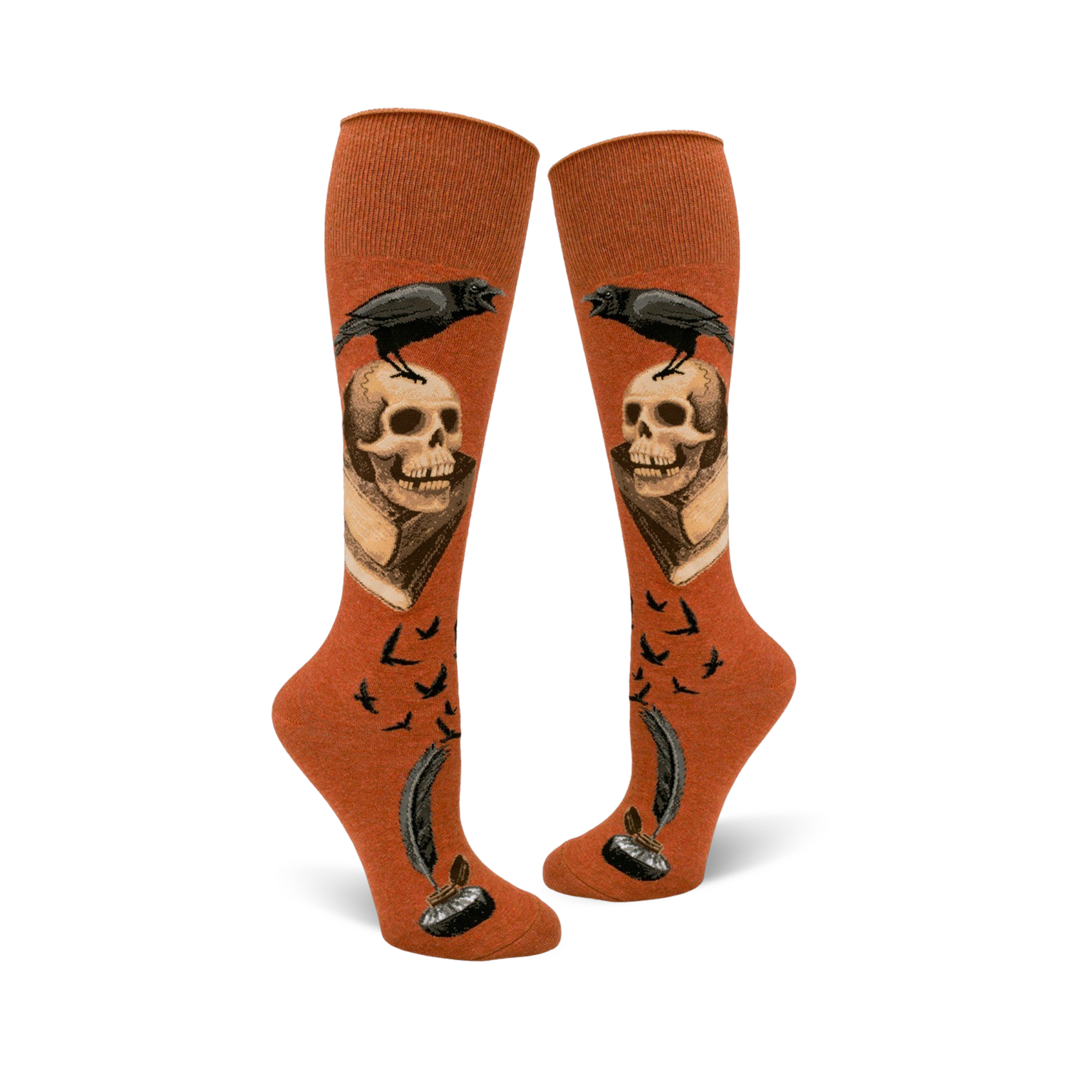 Pair of rust-colored knee-high socks. Design includes a raven perched on a skull above an antique book, quill pen, inkwell, and flying birds.