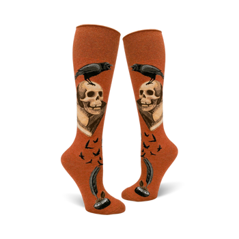 orange knee-high socks adorned with skulls, ravens, and feathersâ€”an eerie touch for halloween.  