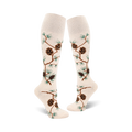 Pair of off-white knee-high socks with brown pine cones and green pine branches artfully arranged on the fabric.