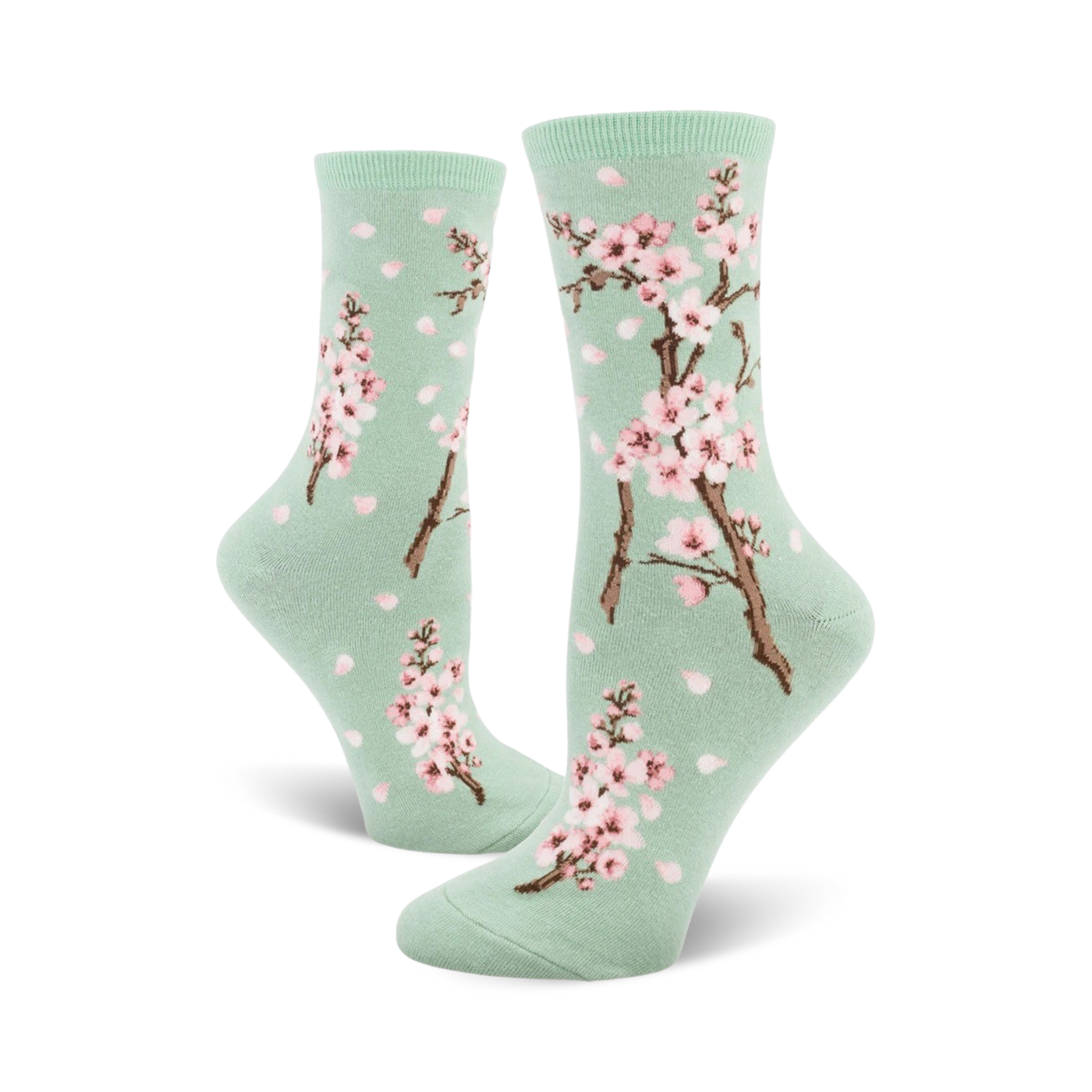 Pair of crew socks with a pastel green background, pink cherry blossoms, and falling petals design.