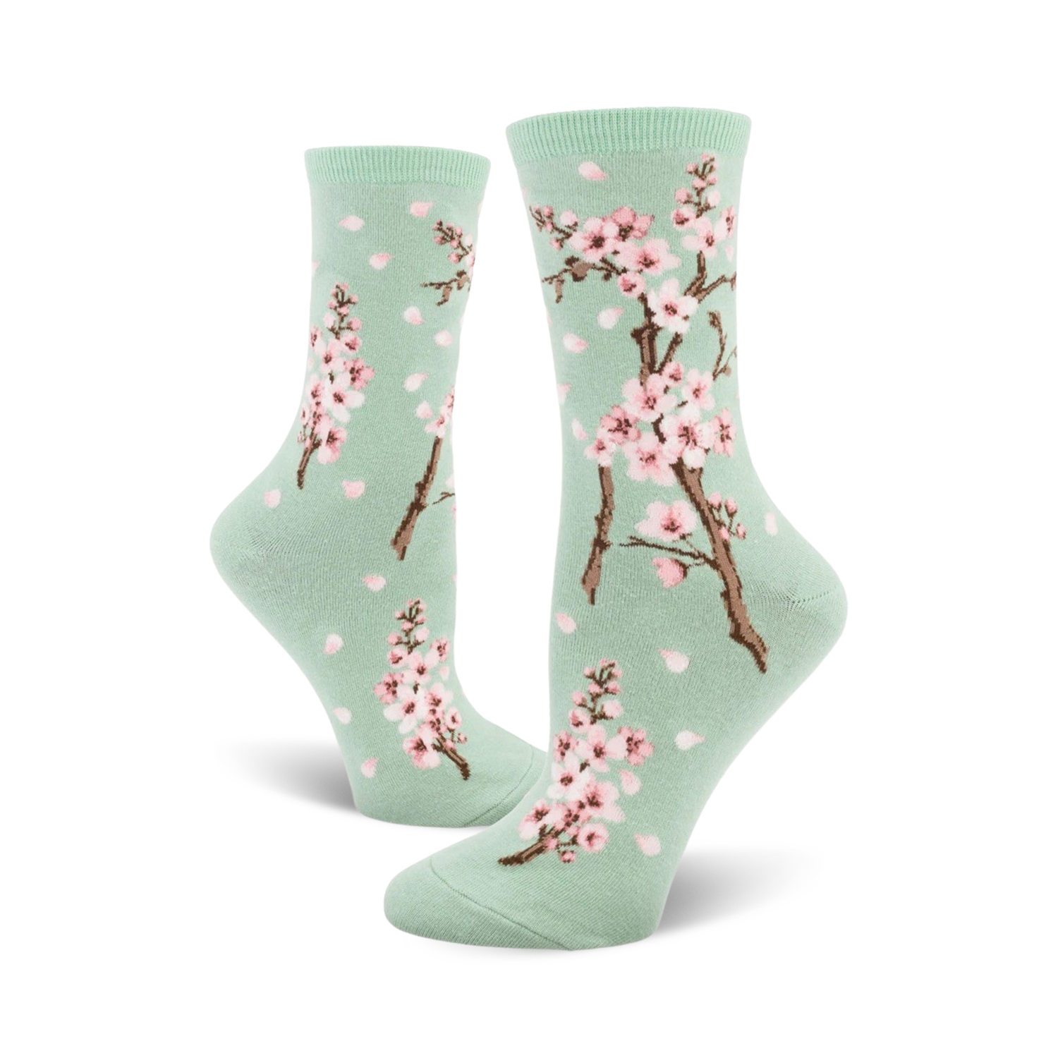 Pair of crew socks with a pastel green background, pink cherry blossoms, and falling petals design.