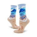 A pair of women's crew socks showcasing a beach scene with blue waves, tan sand, seashells, starfish, and the text '100% That Beach'.