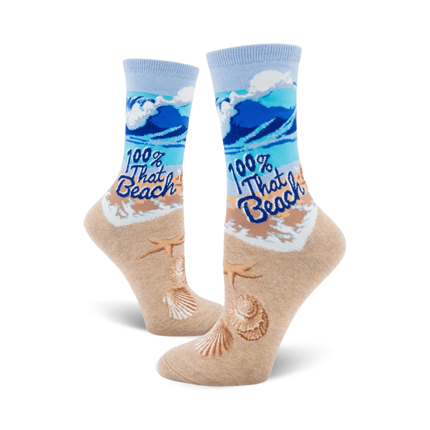A pair of women's crew socks showcasing a beach scene with blue waves, tan sand, seashells, starfish, and the text '100% That Beach'.