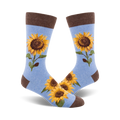 A pair of light blue crew socks with a brown cuff.  Sunflowers are printed on the socks.
