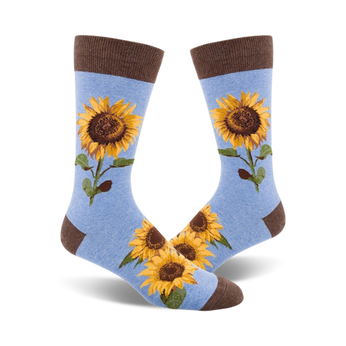 A pair of light blue crew socks with a brown cuff.  Sunflowers are printed on the socks.