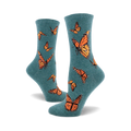 A pair of teal crew socks featuring a pattern of orange monarch butterflies. The socks are shown from the side, showcasing the design.