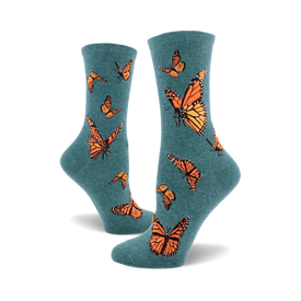 the teal blue socks have a pattern of monarch butterflies. the butterflies are orange, black, and white.