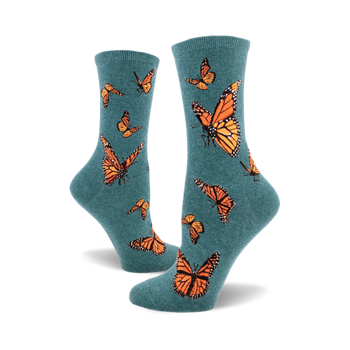the teal blue socks have a pattern of monarch butterflies. the butterflies are orange, black, and white.